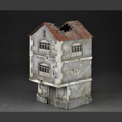 Two-story building with bullet holes and bombed roof